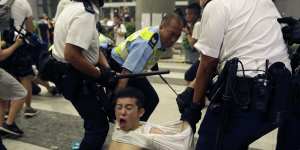 Police drag a protester away.