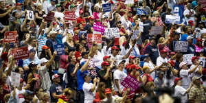 Attendees hold placards,including ones with the letter'Q',and cheer during a rally with US President Donald Trump.