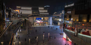 People walk in the courtyard of a shopping mall after local authorities asked restaurants in the area to only serve takeaway food and some stores to close in an effort to prevent the spread of COVID-19 in Chaoyang District on November 18.