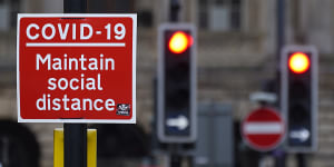 A social distancing sign is affixed next to traffic light signals ahead of the lockdown closure of bars,gyms and clubs in Liverpool.