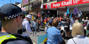 Climate activists,flanked by ‘Blinky’ the smoke-breathing Koala,gather outside Labor MP Peter Khalil’s office in Melbourne’s north.