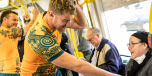 Wallabies lock Matt Philip makes conversation with Melbourne commuters on a tram in the city on Wednesday.