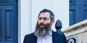 Rabbi Dovid Gutnick outside the charred entrance to the East Melbourne Synagogue.