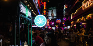 A pedestrian walks past a Star Buds marijuana stand on Soi Cowboy in Asok,Bangkok.