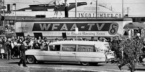 People line the street as the hearse bearing the body of US. President John F. Kennedy drives past.