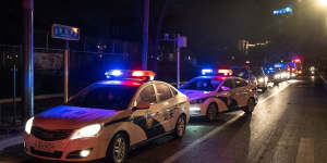 Police cars line up near the site of a planned protest in Beijing on Tuesday night.