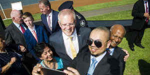 Prime Minister Scott Morrison takes a photo with new Australian citizens Farina Ahmed,Shahzad Ahmed and Iftikhar Ahmed on Saturday morning.