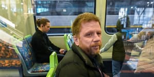 Rick Gned on the train during his long commute to work in Melbourne’s inner east.