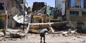 A man photographs a building that collapsed after an earthquake shook Machala,Ecuador on Saturday.