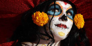 A woman dressed as Mexico's iconic'Catrina'awaits the start of the grand procession of the Catrinas,part of the Day of the Dead celebrations in Mexico City.