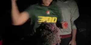 A screengrab from the footage,which shows the man standing in a barrel of bloodied water as he is beaten and cut by a mob.