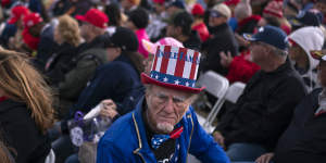 A supporter dressed as Uncle Sam sits among the crowd at a rally for former president Donald Trump in Arizona.