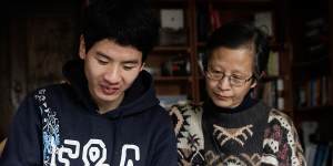 Tim Chan uses an electronic voice-output device,with his mother Sarah Chan,in 2014.