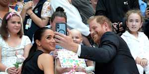 Meghan,Duchess of Sussex and Prince Harry,Duke of Sussex pose for a selfie with children and their families during a visit to the Royal Children’s Hospital.
