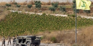 Lebanese soldiers next to a Hezbollah flag patrol in the southern Lebanese village of Aitaroun,on the Israel-Lebanon border,Israel,Tuesday,Aug. 27,2019. Israeli forces along the border with Lebanon are on high alert,raising fears of a repeat of the 2006 war. (AP Photo/Ariel Schalit)