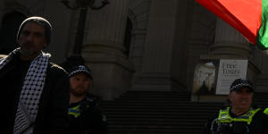 A pro-Palestine protester waves a flag outside Parliament House in the CBD. 