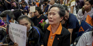 A supporter of Thailand's Future Forward Party cries as they watch a live television broadcast of a court verdict at their party's headquarters in Bangkok on Friday.
