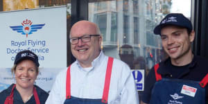 Australia’s High Commissioner to the UK George Brandis serves democracy sausages to voters at Australia House in London. 