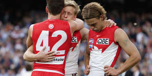 Swans midfielder Robbie Fox (in number 42) consoles Isaac Heeney and James Rowbottom.