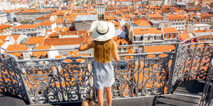 Young woman tourist enjoying beautiful cityscape top view on the old town during the sunny day in Lisbon city,Portugal iStock image for Traveller. Re-use permitted.