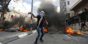 Palestinians sling stones during clashes with Israeli troops.