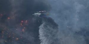 A helicopter dumps water on fires in Kalamaki,about 60 kilometres west of Athens.