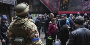 Ukrainian servicemen distribute water to people in Mariupol.