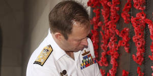 Chief of Navy Vice-Admiral Michael Noonan places a poppy next to Able Seaman Thomas Welsby Clark’s name on the Roll of Honour at the Australian War Memorial on Friday.