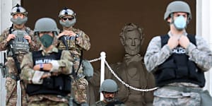 Protesters march to Lincoln Memorial lined by National Guard