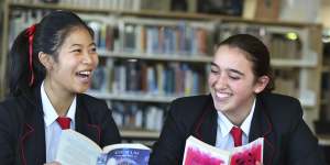 Year 10 Queenwood students Penny Jin and Lucy Colquhoun-Thomson with their books at the school’s library.