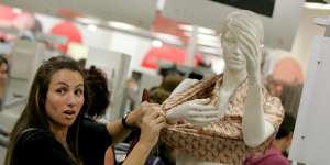 Sold like hotcakes ... a woman strips a mannequin for a Stella McCartney item at Target in 2007.