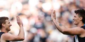 Will Hoskin-Elliott celebrates a goal with teammate Brody Mihocek during the Pies’ clash with Port Adelaide.