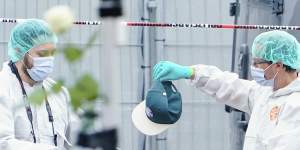 A forensic police officer work holds a cap at the scene of a knife attack at the market square in Mannheim,Germany.