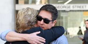 The brother of Fabiana Palhares,Raphael Palhares (right),is consoled after leaving the Supreme Court in Brisbane.