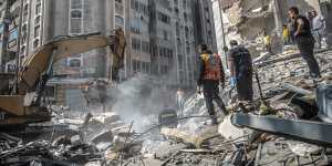 Palestinians search for survivors in a destroyed building after an Israeli air strike in Gaza City on Sunday.