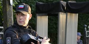 A police officer with an anti-drone gun at the entrance of the Porokhovskoye cemetery in St Petersburg.