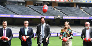 James Warburton and Patrick Delany (from left) pose for a photo with former AFL CEO Gillon McLachlan at the announcement of the code’s broadcast deal in 2022.