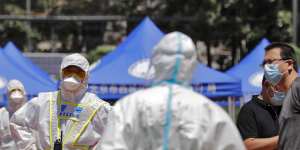 A policeman wearing a protective suit stands watch at the Xinfadi wholesale market. 