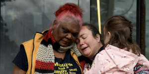 Ruby Dykes (left) and Fleur Magic Dennis,family members of Douglas “Mootijah” Shillingsworth,hug outside court on Friday. 