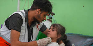 A medic treats an injured child after Israeli airstrikes in the Rimal district of Gaza City.