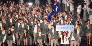 Eddie Ockenden and Rachael Grinham,flag bearers of Team Australis,lead their team out during the opening ceremony.