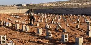 A man walks by the graves of the flash flood victims in Derna,Libya.