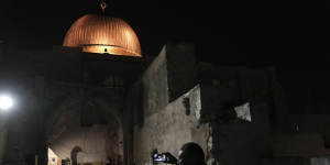 A Palestinian worshipper films the aftermath of a raid by Israeli police at the al-Aqsa Mosque compound on Wednesday.