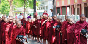 Young buddhist novices walk to collect alms and offerings in the monastery of Maha Gandhayon Kyaung.