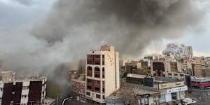 Plumes of smoke from two simultaneous strikes rise over Tehran on Monday.