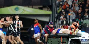 Jack Viney clashes with Magpie Brayden Maynard as teammate Angus Brayshaw is taken off the field on a stretcher.