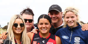 Madison Prespakis of the Bombers and Georgie Prespakis of the Cats pose with family members after the teams clashed.