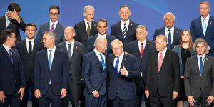 British Prime Minister Boris Johnson stands beside US President Joe Biden and other world leaders during the NATO summit.