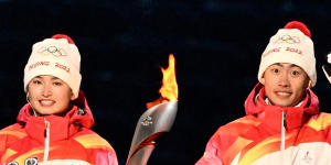 The Olympic cauldron is lit by China’s athletes Dinigeer Yilamujian and Zhao Jiawen.