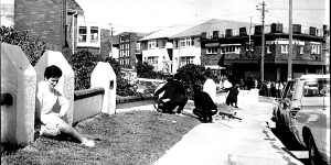 Passers-by shelter behind fences near the scene of the siege in Hastings Parade,Bondi on September 9,1969